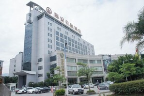 Un hotel de varios pisos con fachada moderna, amplias ventanas y una entrada destacada.