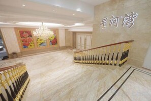 A grand lobby with a marble floor, a chandelier, and a staircase with golden railings. - Fu'an Exhibition Hotel (Fu'an)