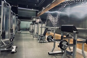 Un gimnasio con diversos equipos de ejercicio, incluyendo máquinas de pesas y pesas libres.