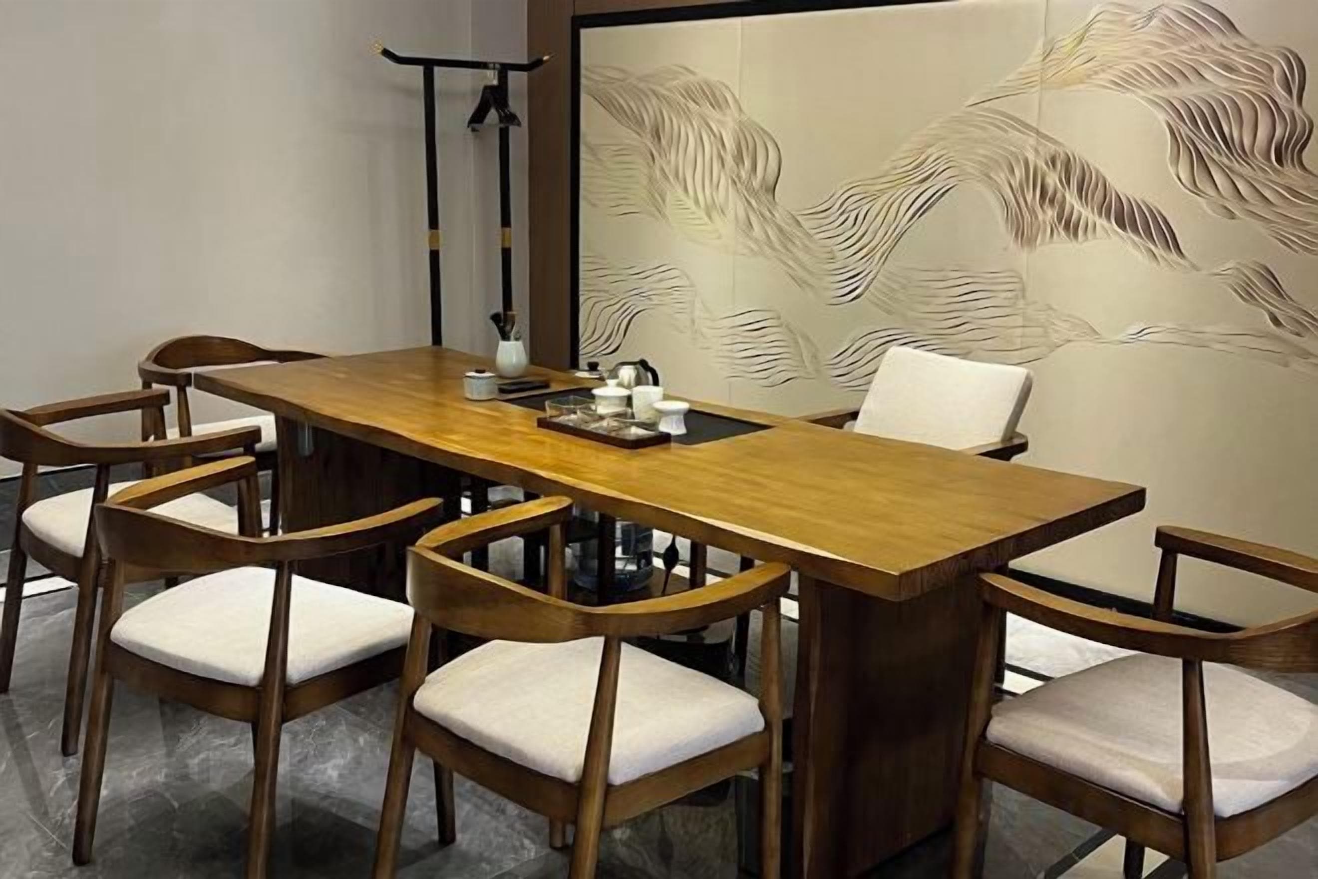 A conference room with a long wooden table and six chairs with cushioned seats.