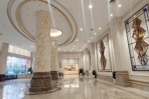 A spacious lobby with marble columns, a large chandelier, and a modern art piece on the wall. - Fu'an Exhibition Hotel (Fu'an)