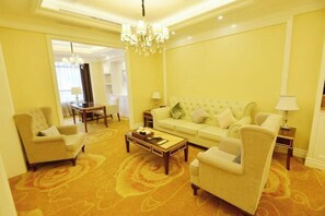 A hotel room with a sofa, armchairs, a coffee table, a chandelier, and a carpeted floor. - Fu'an Exhibition Hotel (Fu'an)