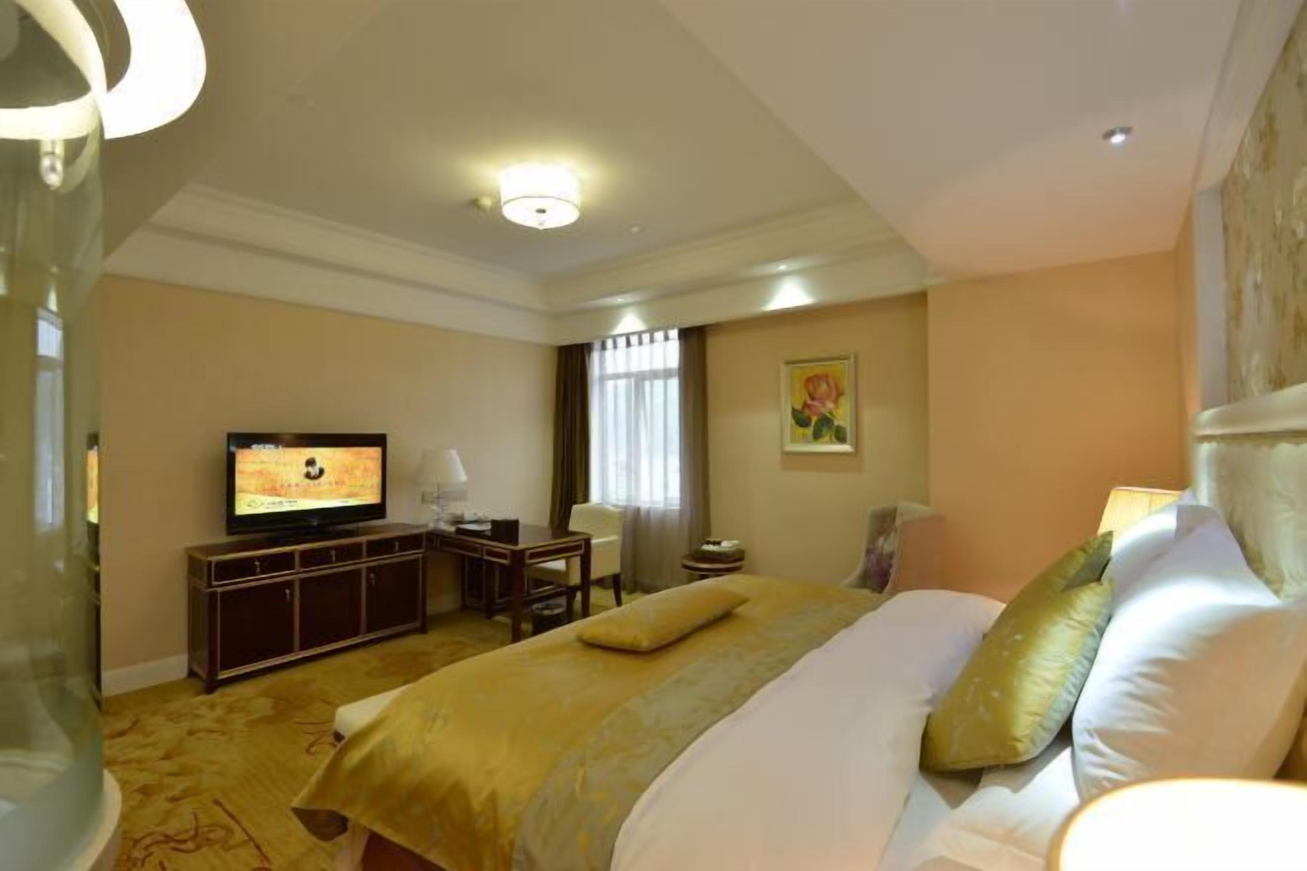 Une chambre d’hôtel équipée d’un lit, d’une télévision, d’un bureau et d’une chaise.