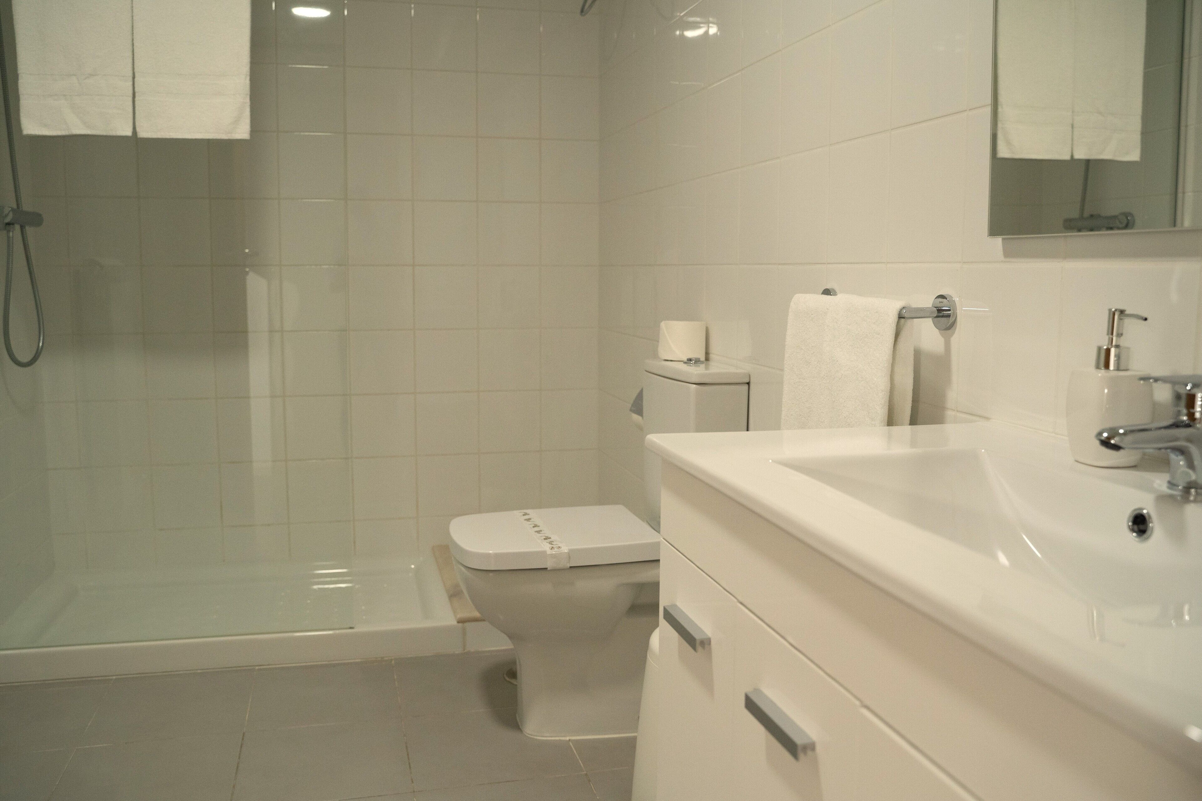 Un baño moderno con ducha, inodoro y lavabo.