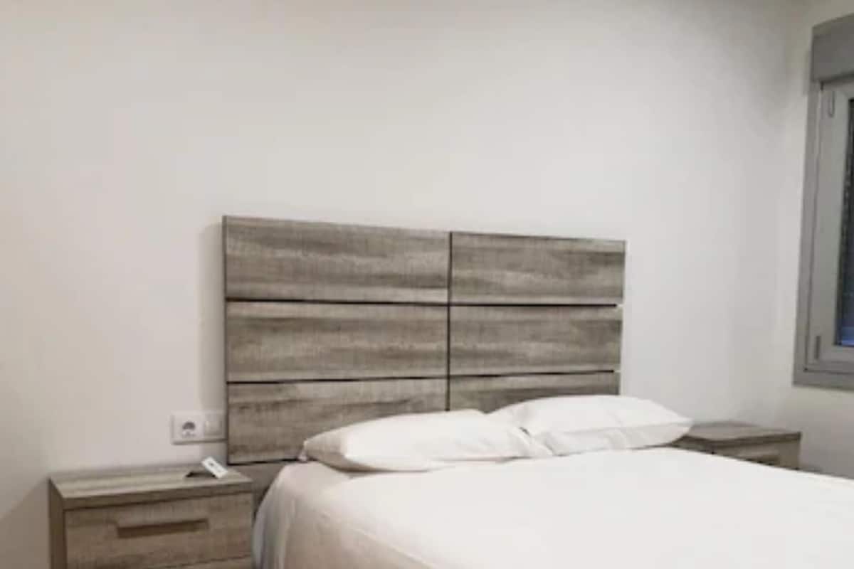 A bedroom with a bed, a nightstand, and a dresser.