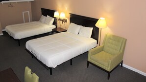 Una habitación de hotel con dos camas, una silla y lámparas de noche.