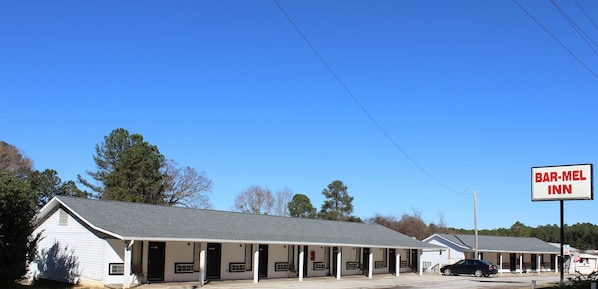 A Bar-Mel Inn with a simple, single-story structure and a covered parking area.
