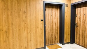 An elevator with a wooden wall and a black frame, marked with the number 80. - Apartamenty Bema od WroclawApartament-pl (Wroclaw)