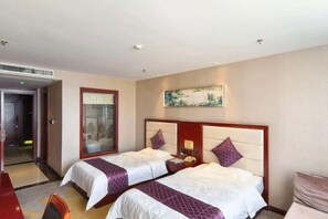 A hotel room with two beds, a desk, and a painting on the wall. - Jinyue International Hotel (Changtu)