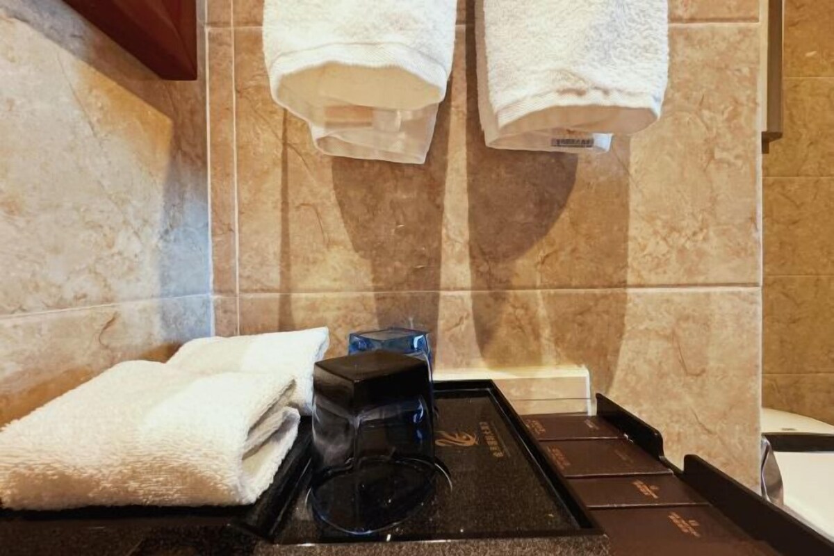 A bathroom with a towel rack, a coffee machine, and a black tray.