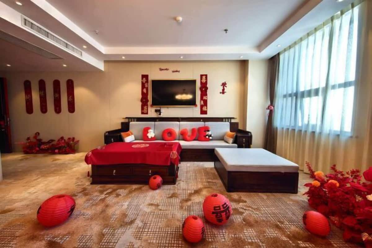 A modern living room with a sofa, a flat-screen TV, and decorative elements.