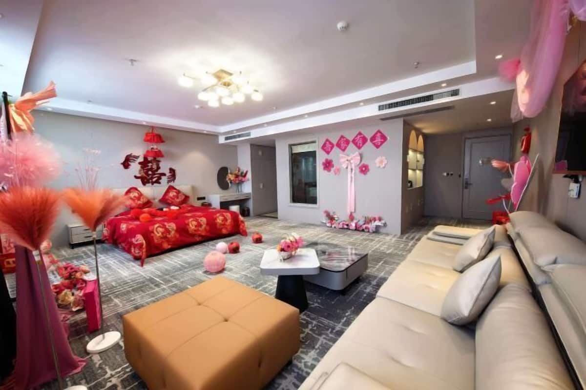 A modern living room with a sofa, ottoman, and a coffee table.