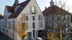 A hotel with a traditional European architectural style, featuring a steeply pitched roof and a prominent tower.