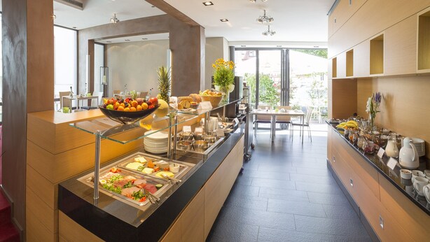 A buffet area with various food options, including fruits, vegetables, and meats.