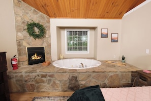 Enjoy a warm ambiance with a fireplace, bathtub, and outdoor views.