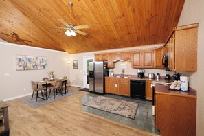 Enjoy cooking in this well-equipped kitchen with a central island, stainless steel appliances, and a dining area.