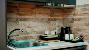 A kitchen with a stainless steel sink, a coffee maker, and a cutting board on the counter. - Dim House (Parga)