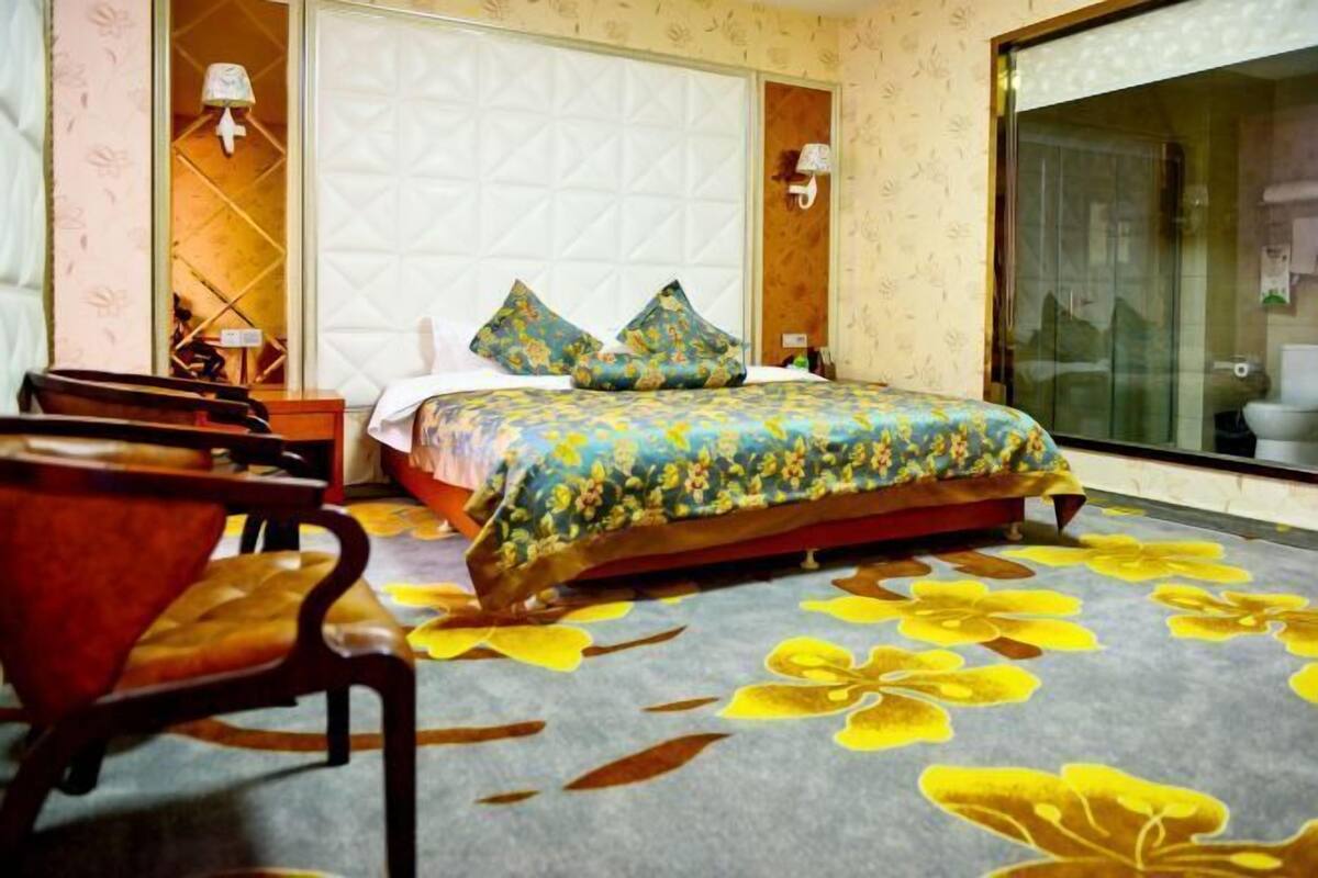 A hotel room with a bed, a desk, and a chair.