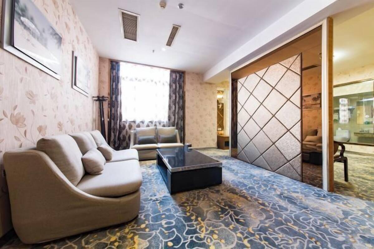 A modern living room with a sofa, a coffee table, and a patterned carpet.