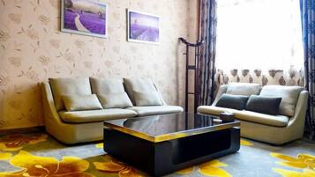 A living room with two sofas, a coffee table, and floral-patterned carpet.