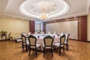 A dining area with a round table, chairs, and a chandelier. - She Yang Hotel (Sheyang)
