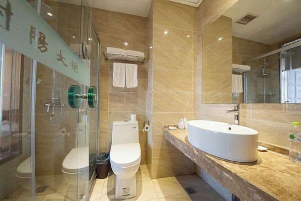 A modern bathroom with a glass-enclosed shower, a toilet, and a large sink with a mirror. - She Yang Hotel (Sheyang)