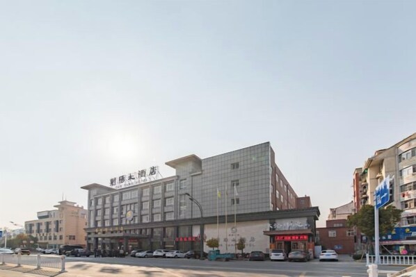 Un hôtel à plusieurs étages doté d’une architecture moderne, caractérisé par une entrée imposante et une signalétique bien visible.