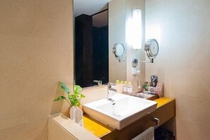 A modern bathroom with a large mirror, a white sink, and a plant on the counter. - She Yang Hotel (Sheyang)