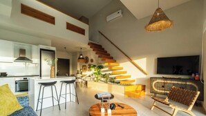 A modern living room with a sofa, coffee table, and a staircase leading to an upper level. - Villa Jarko (Chania)