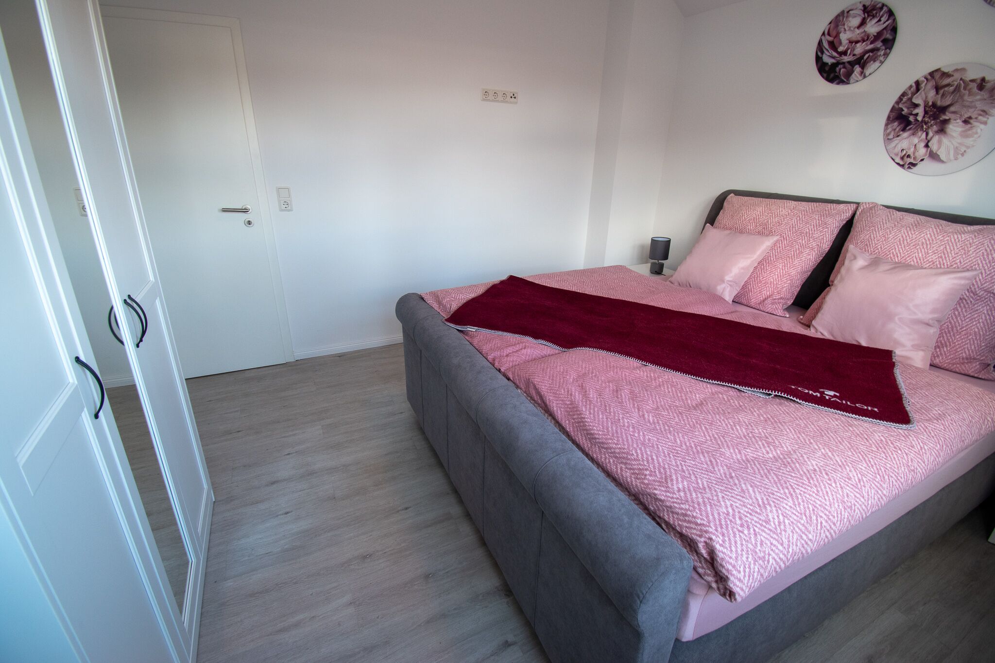 Une chambre à coucher avec un lit, une porte et un mur muni d’une prise de courant.