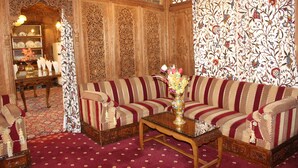 Una habitación tradicional con un conjunto de sofás, una mesa de centro y un papel tapiz decorado.