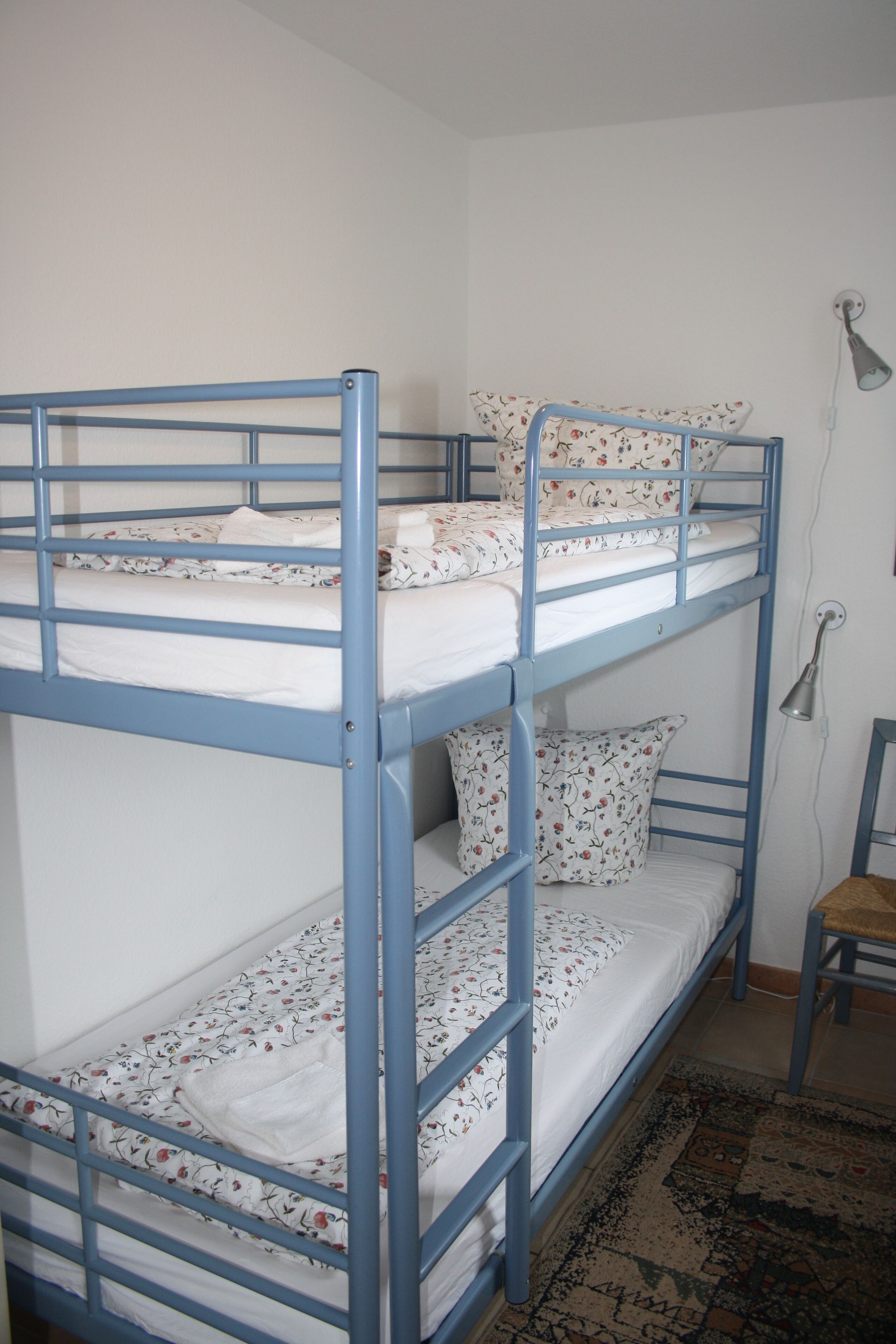Una camera con un letto a castello, una scrivania e una sedia.