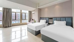 A hotel room with two beds, a large window, and a view of buildings. - Wanpeng Hotel (Zhanjiang Suixi Quanfeng Plaza Branch) (Suixi)