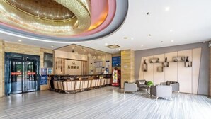 A modern hotel lobby with a reception desk, seating area, and a unique ceiling design. - Wanpeng Hotel (Zhanjiang Suixi Quanfeng Plaza Branch) (Suixi)