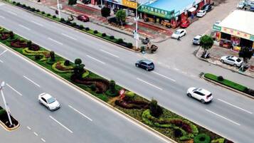 A multi-lane road with vehicles, a gas station, and commercial buildings.
