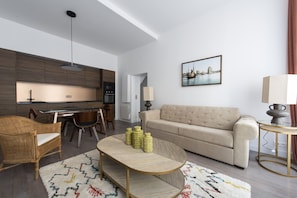 Relax in this stylish living room with a sofa, coffee table, and wicker chair.