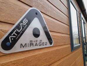 A sign on a wooden wall indicating the room size as 35 x 12 - 2B, named MIRAGE2, part of the ATLAS LEISURE HOMES. - 12A Beautiful Lodge Home For Hire 2 Bedrooms (Forfar)
