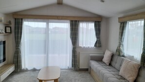 Ein gemütliches Wohnzimmer mit einer Couch, einem Tisch und einem Fernseher.