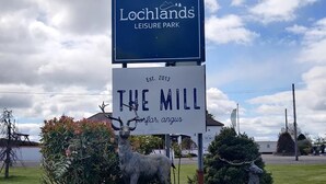 Schild für den Lochlands Leisure Park mit einer Hirschstatue und einem Schild für The Mill.
