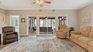 A spacious living room with a large rug, leather chairs, and a ceiling fan. - Dog Friendly, 370+ ft of Waterfront, dock access and kayaks! (Littleton)