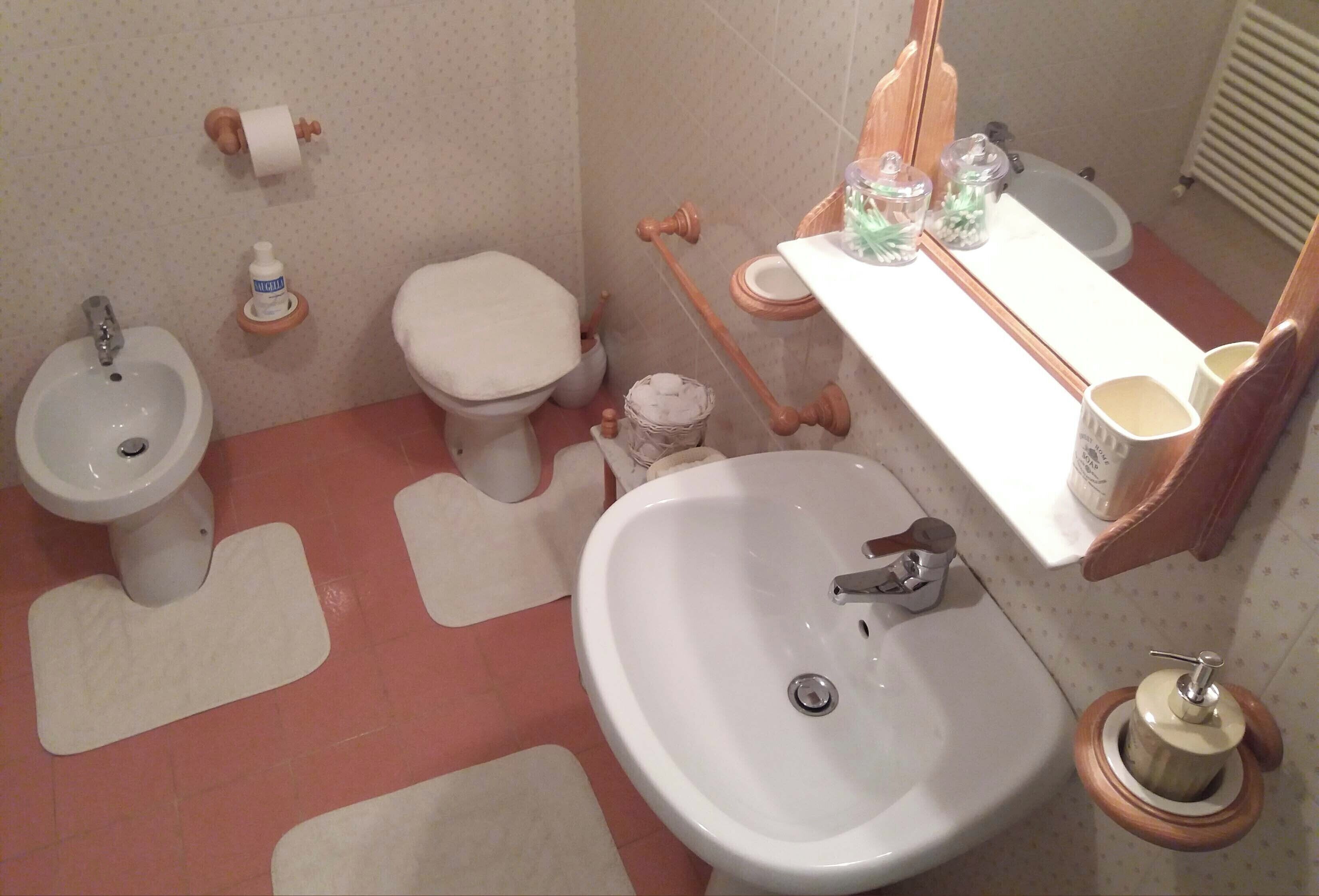 Une salle de bain équipée d’un bidet, de toilettes, d’un lavabo et d’un miroir.