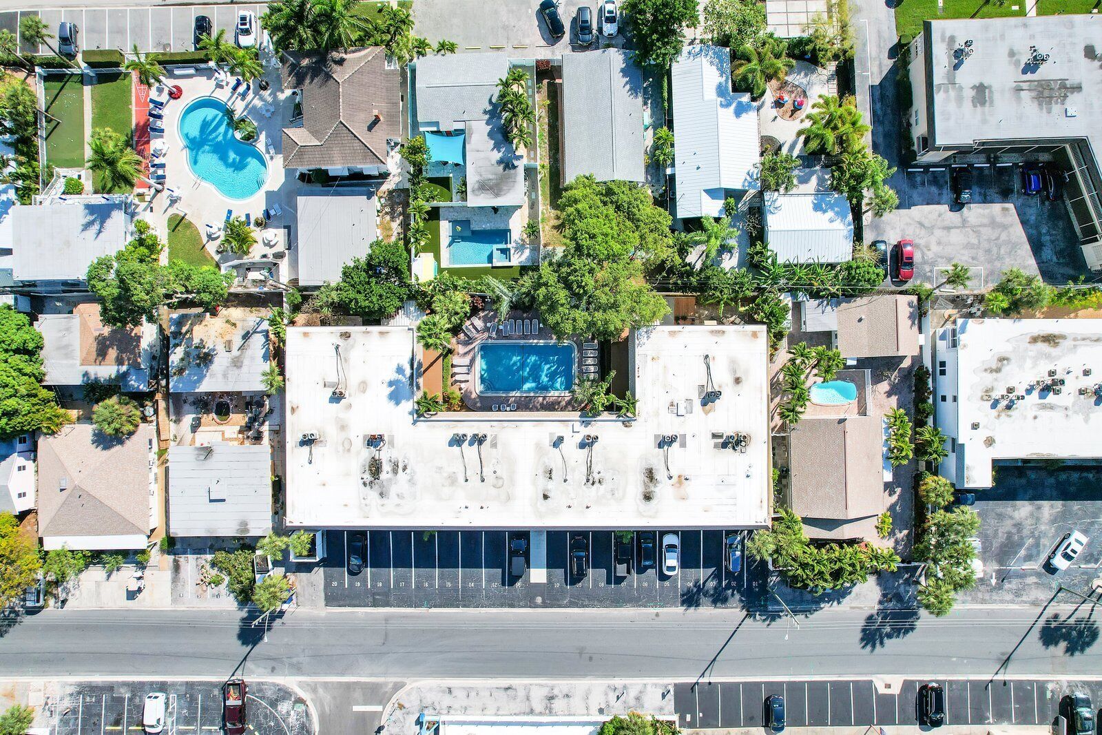 Une vue aérienne d’un hôtel comprenant plusieurs bâtiments, une piscine et un parking.