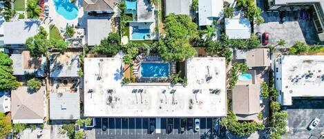 Une vue aérienne d’un hôtel comprenant plusieurs bâtiments, une piscine et un parking.