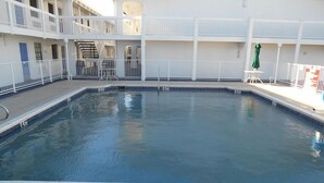 A 5 ft. indoor pool with a white railing, a sign indicating no diving, and a staircase leading to an upper level. - Motel6 Garland, TX - Northeast Dallas (Garland)