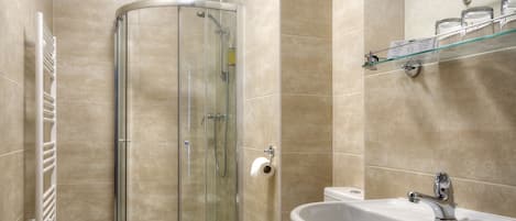 Une salle de bain moderne avec une douche à parois de verre, des toilettes, un lavabo et un porte-serviettes.