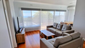 En moderne stue med sofa, sofabord og fjernsyn.