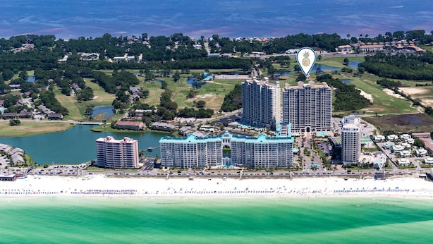 Um resort costeiro com vários hotéis altos, uma orla e um campo de golfe.