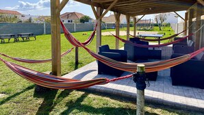 Eine Holzpergola mit Hängematte und Sitzgelegenheit im Freien.