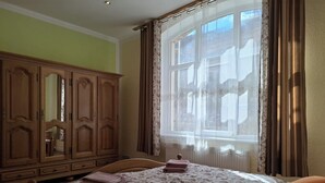 Una camera da letto con un letto, un armadio in legno e una finestra con tende.