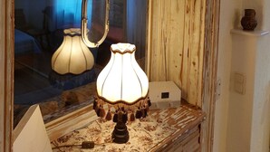 Una stanza rustica con una toeletta in legno, uno specchio e una lampada.